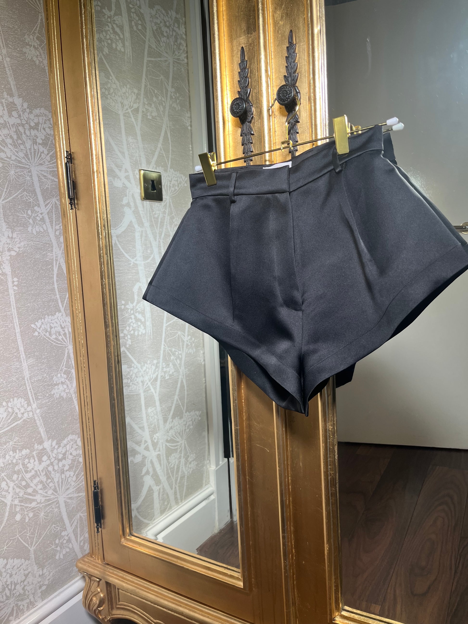 Black structured tailored style women’s short luxurious satin fabric made with mini length & zip front closure